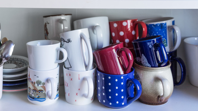 stacked mugs inside kitchen cabinet