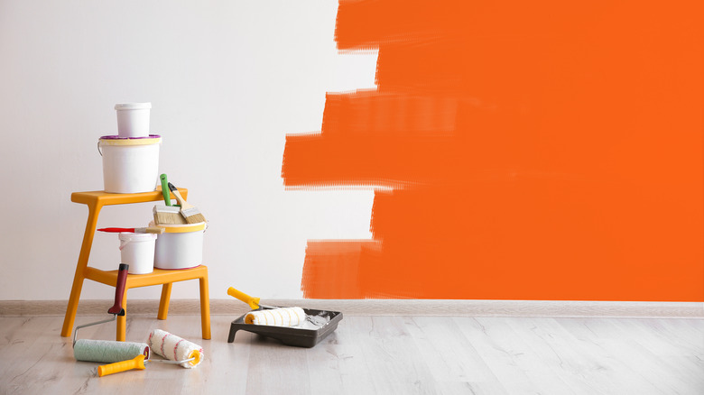 Painting supplies and orange and white wall