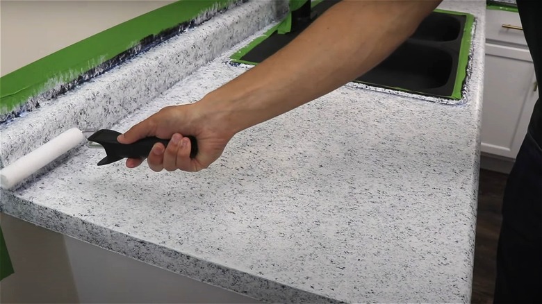 person painting granite countertop