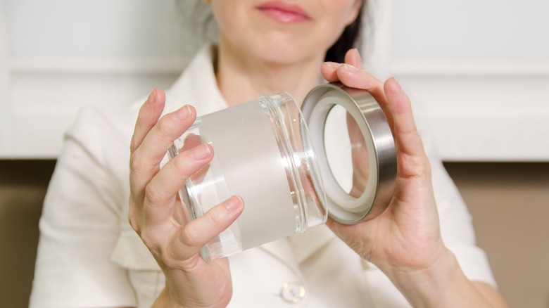 woman closing lid on jar