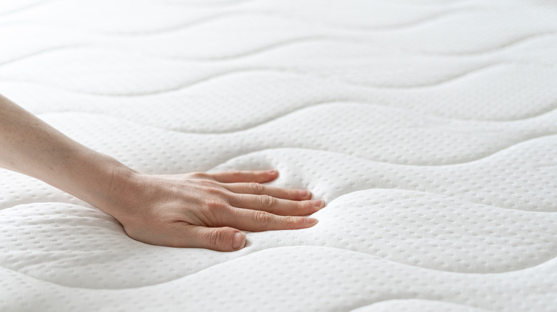 Woman touching soft mattress